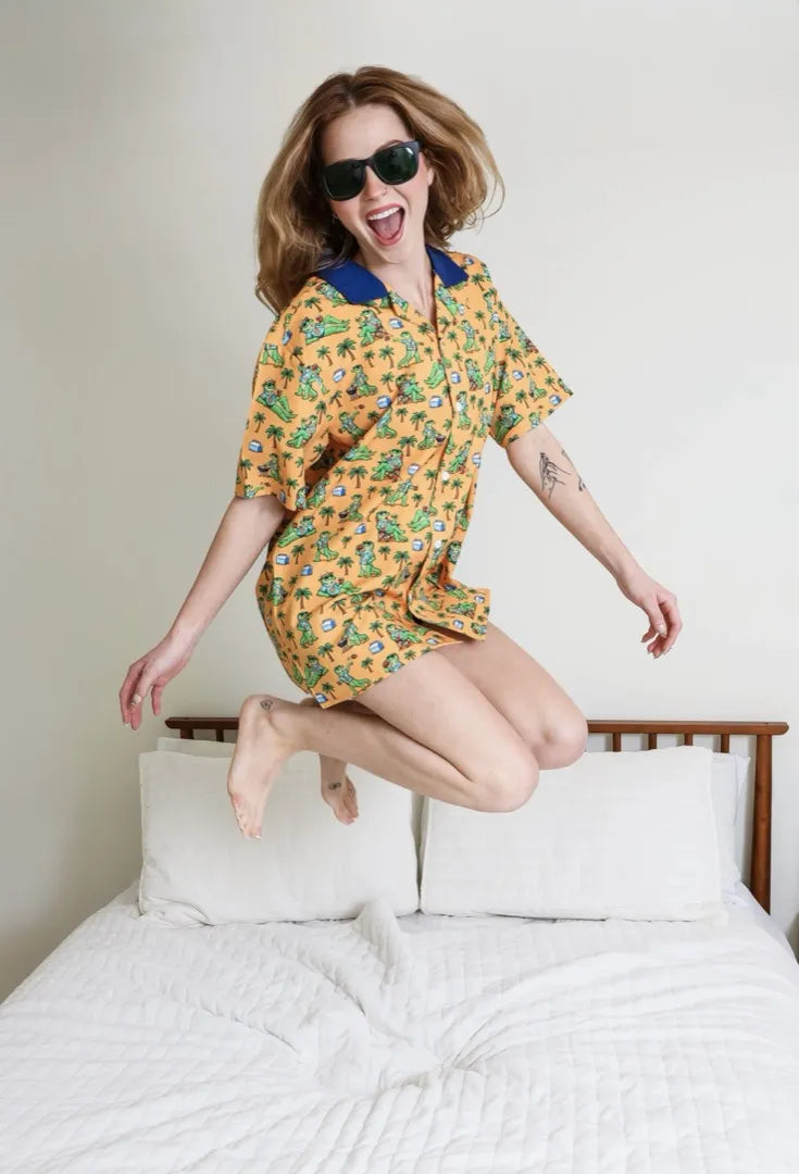 A woman in sunglasses jumping on a bed in the Tailgatin' Gator Style shirt