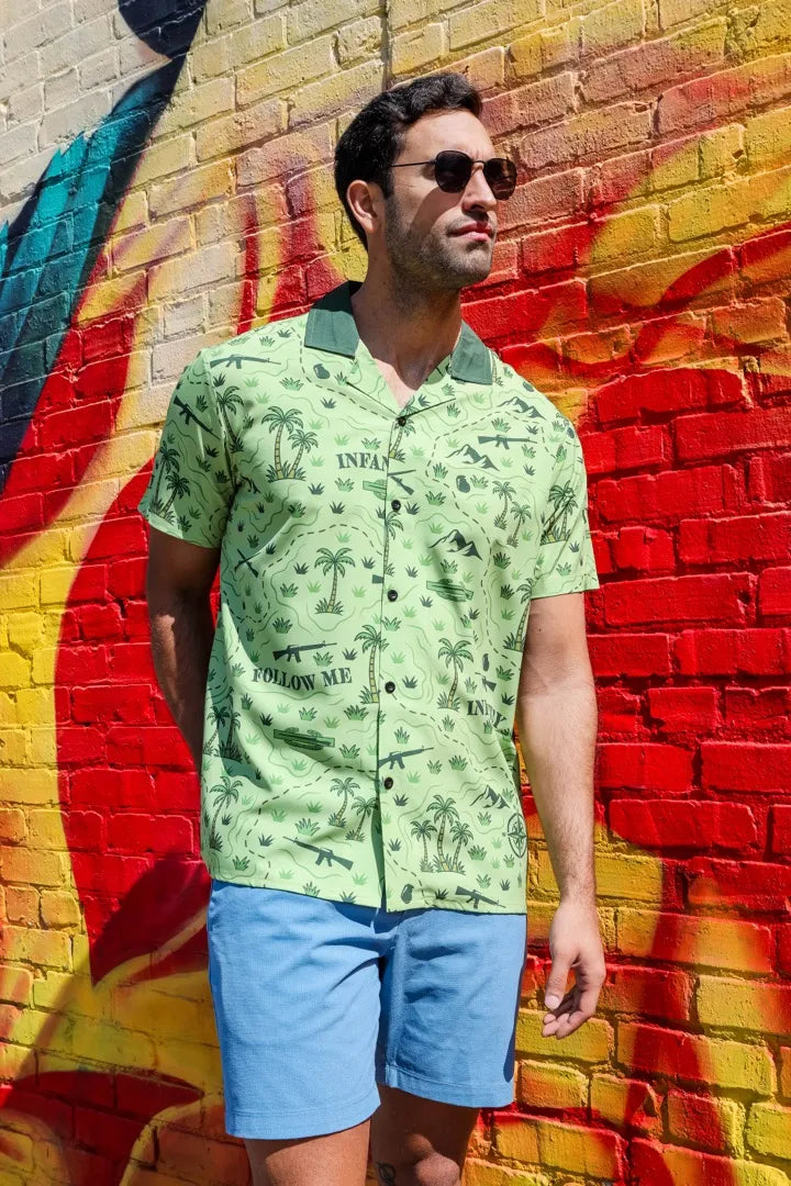 A man in sunglasses in the Follow Me shirt in front of a red and yellow graffiti wall