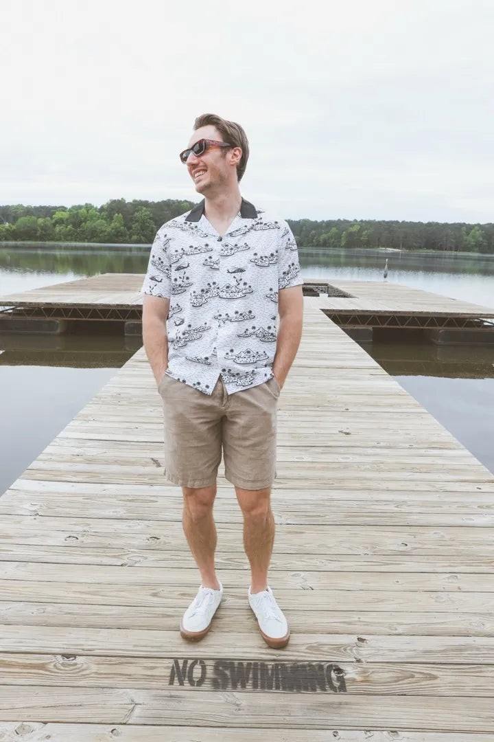A man in the Smooth Insertions Only shirt standing on a dock marked No Swimming